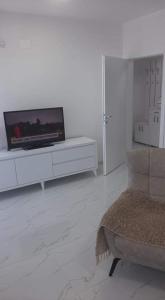斯特鲁加Ohrid-Struga Ezerski Lozja的客厅配有白色橱柜上的平面电视