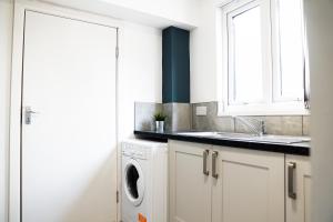 利物浦Charming Retreat in the heart of the City的白色的厨房配有水槽和洗衣机