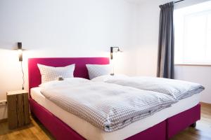 加尔米施-帕滕基兴Guade Stub´n的一间卧室配有一张大床和紫色床头板