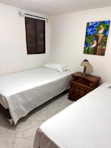 麦德林Acogedor apartamento cerca al centro de Medellin的配有桌子和窗户的客房内的两张床