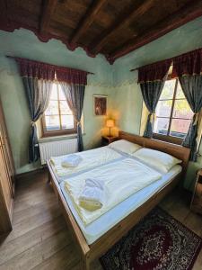 克拉尼斯卡戈拉Apartments Belopeški Dvori的一间卧室设有一张大床和两个窗户。