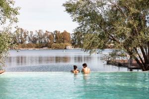 卡斯特沃托诺Nabi Resort Glamping & SPA的站在湖水中的男人和女人