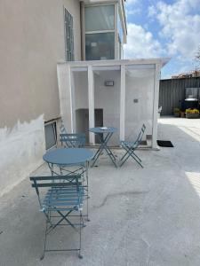 博斯科雷亚莱B&B VILLA LA GINESTRA - camere的两把桌子和椅子坐在大楼外