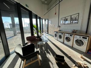 卡托维兹Apartament Manhattan Premium - I-wsza Dzielnica - by Kairos Apartments的洗衣房配有多台洗衣机和椅子