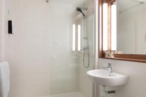 多勒钟楼多勒酒店的白色的浴室设有水槽和淋浴。