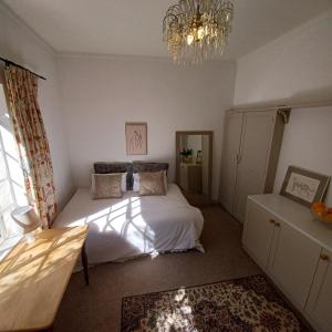 约翰内斯堡Craighall Park Stylish Garden Studio的一间卧室配有一张床和一个吊灯