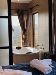 乌鲁比西Cabanas Sunset View的带浴缸的浴室和大窗户