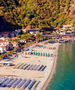希拉Mare e Monti的海滩上设有椅子和遮阳伞,水面