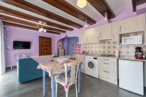 博尔塔纳Casa Dieste Apartamentos Turísticos en Boltaña的厨房拥有紫色的墙壁,配有桌椅