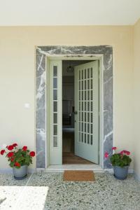 希俄斯Mosaic Luxury House的一间房间里开有两盆花的大门