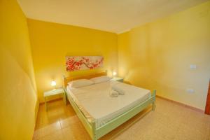 斯廷蒂诺Casa Vacanza Sole & Luna的一间卧室配有一张黄色墙壁的床和两盏灯。