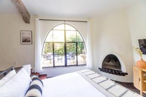 MontecitoCasa Blanca Suite A1 - New, Private, Cozy!的一间卧室配有一张床和一个壁炉