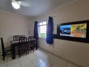 桑托斯Pé na Areia的客厅配有餐桌和平面电视。