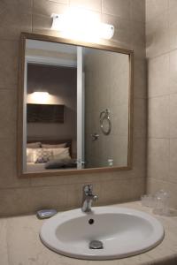 阿约斯尼奇塔斯Arenaria Leucadia的浴室水槽和上面的大镜子