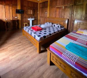 日惹Jogja Classic Homestay Syariah的木墙客房的两张床