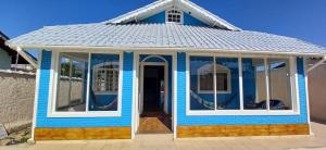 佩鲁伊比Hostel Litoral的一间拥有许多窗户的小蓝色房子