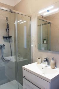 苏提万Apartment Limoni的一间带水槽和玻璃淋浴的浴室