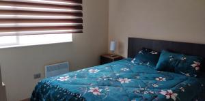 比亚里卡Apartamento Villarrica的一间卧室配有一张带蓝色棉被的床和窗户。