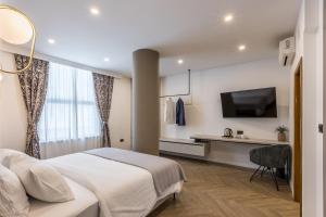 斯普利特Luxury rooms Bolero的一间卧室配有一张床、一张书桌和一台电视