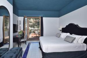 波西塔诺Luxury Suite Royal Positano的一间带大床的卧室和一个阳台