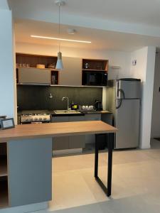 乌斯怀亚Departamento Rosas的厨房配有木桌和冰箱。