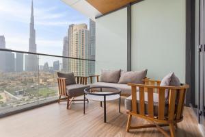 迪拜Ramee Dream Hotel Downtown的阳台设有带沙发和椅子的客厅