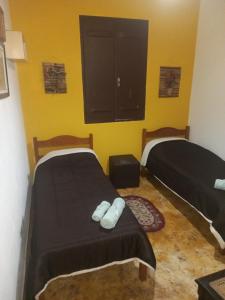 圣本图-杜萨普卡伊Mini Casarão的黄色墙壁客房的两张床