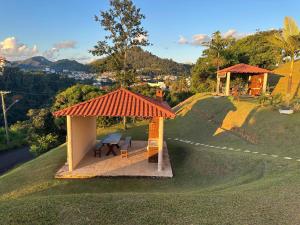 阿瓜斯迪林多亚A Melhor vista de água de Lindóia的山丘上带野餐桌的凉亭