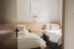 多尼戈尔多尼戈尔河口度假屋的一间卧室配有两张带白色床单和粉红色枕头的床。