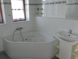 阿尔滕霍尔茨霍提瑙公寓的白色的浴室设有浴缸和水槽。