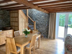 LlanwrdaPippin Lodge的一间带木桌和椅子的用餐室
