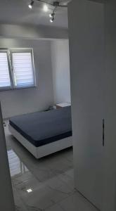 斯特鲁加Apartman Tamara Struga的卧室配有床,位于带2个窗户的房间