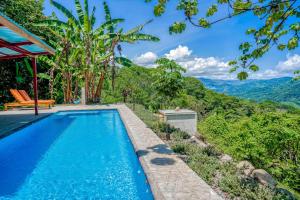 多米尼克Casa Garrobo的一座位于别墅内的游泳池,别墅的背景是群山