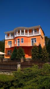 斯塔勒斯普拉维Pension Fami Retro Design的一座橙色的建筑,前面有栅栏