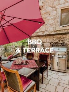 杜布罗夫尼克Sunny Villa, With Pool, BBQ, View, Parking的露台上的一张桌子和一把红色遮阳伞