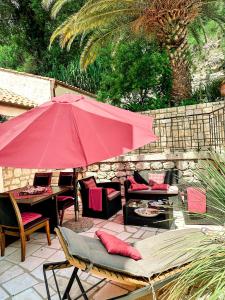 杜布罗夫尼克Sunny Villa, With Pool, BBQ, View, Parking的一个带红色遮阳伞和桌椅的庭院