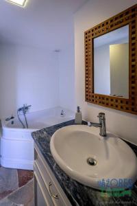 英雄港Casa dos Calços的一间带水槽、浴缸和镜子的浴室