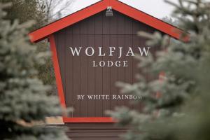 威尔明顿Wolfjaw Lodge的黑红色的建筑,上面写着狼吞虎咽的小屋