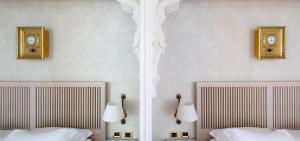 博洛尼亚欧若罗吉奥艺术酒店的两张床位于带两把钟的墙上。