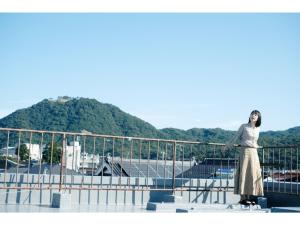 鸟取市Tottori Guest House Miraie BASE - Vacation STAY 41214v的站在扶手顶上的女人