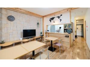 鸟取市Tottori Guest House Miraie BASE - Vacation STAY 41214v的客房设有2张桌子和平面电视。