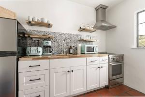 MontecitoCozy New - Casa Blanca Suite B1的厨房配有白色橱柜和炉灶。