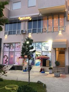 都拉斯apartamente Melodi的建筑物前面的商店,上面有标志