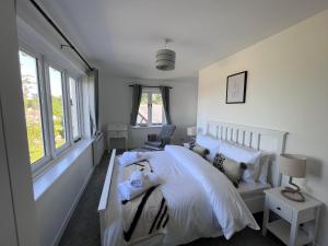 斯塔德兰Studland View Cottage的卧室配有白色的床和窗户。