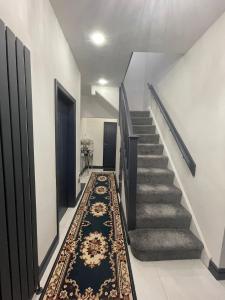 曼彻斯特Luxury Holiday Home的走廊上设有楼梯和地毯