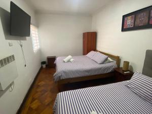 圣地亚哥Atacama Hostel Backpackers的客房设有两张床和一台平面电视。