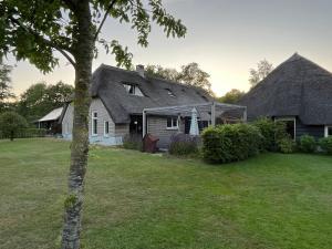 NieuwleusenDe Boerderij - Buitenplaats Ruitenveen, privé的茅草屋顶和庭院的房子