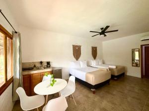 奥尔沃克斯岛La Casa del Sol Holbox的酒店客房带一张床、一张桌子和椅子