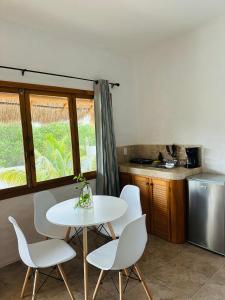 奥尔沃克斯岛La Casa del Sol Holbox的厨房配有白色的桌椅和窗户