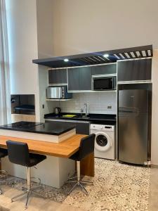埃斯特城Departamento de lujo tipo dúplex的厨房配有木桌和冰箱。